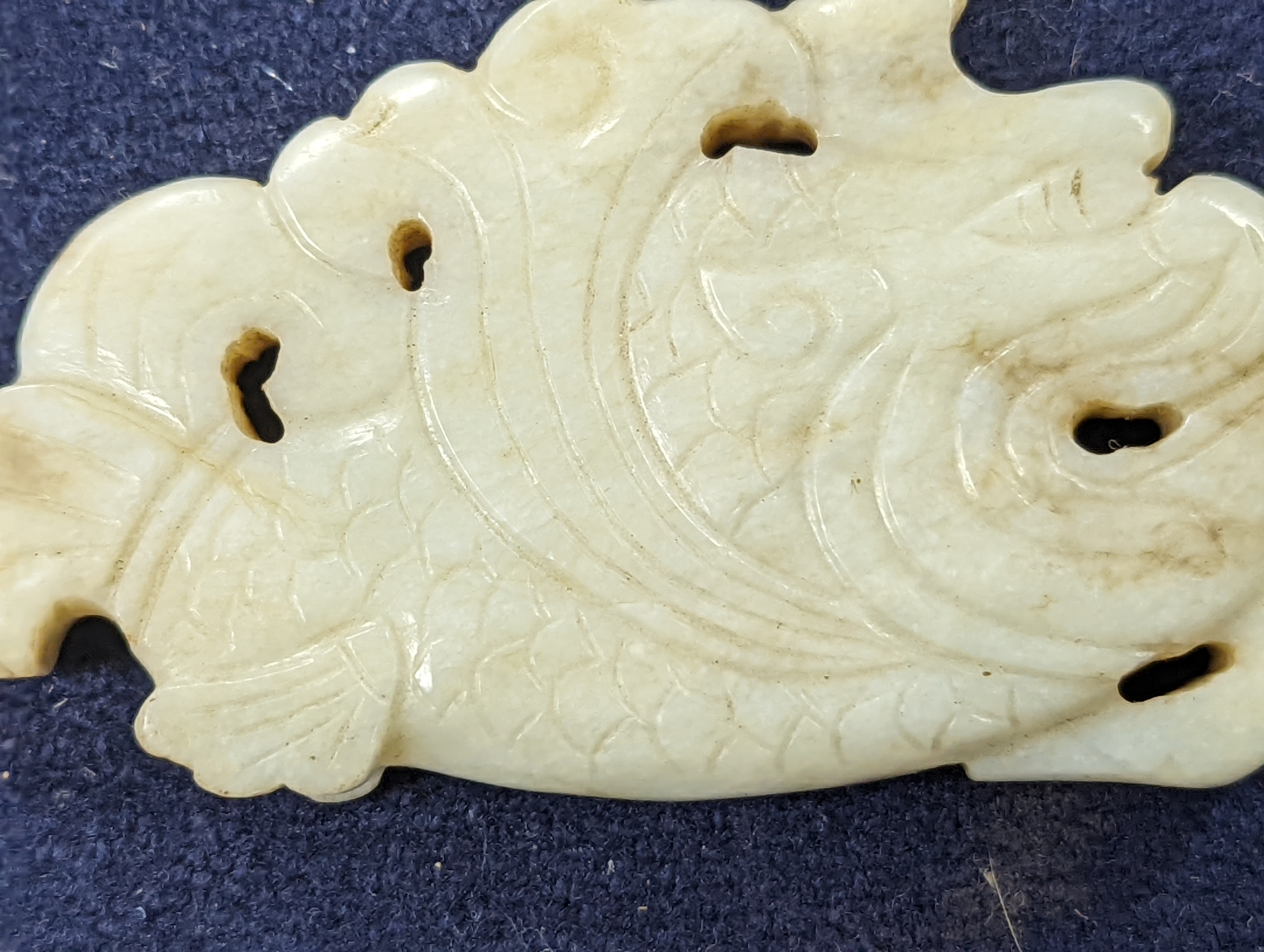 A Chinese white and black jade ‘dragon-fish’ plaque, 19th/20th century, 6cm
